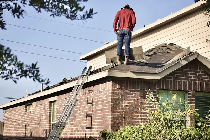Professional roofer working on a residential roof in McAdams
